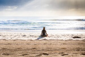 Woman meditating on a beach empaths projection inner knowing intuition