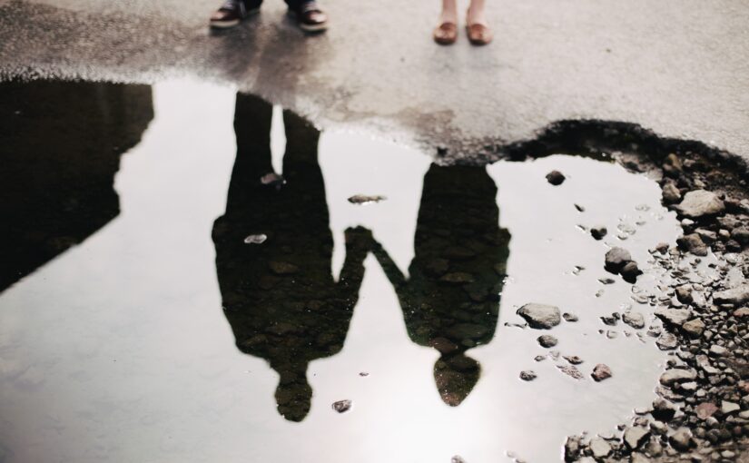 couple in puddle mirror in blog by erin moore, centered one about how empaths in relationships behave when energy low