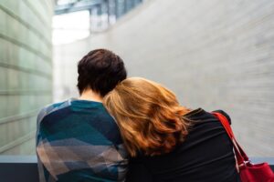 two people leaning on each other in blog article about how empaths deal with grief by erin moore, centered one
