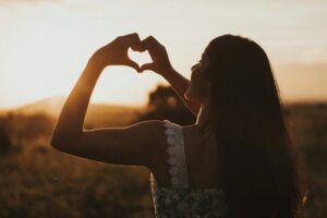 girl making a heart in blog about focusing on self without guilt by erin moore, centered one