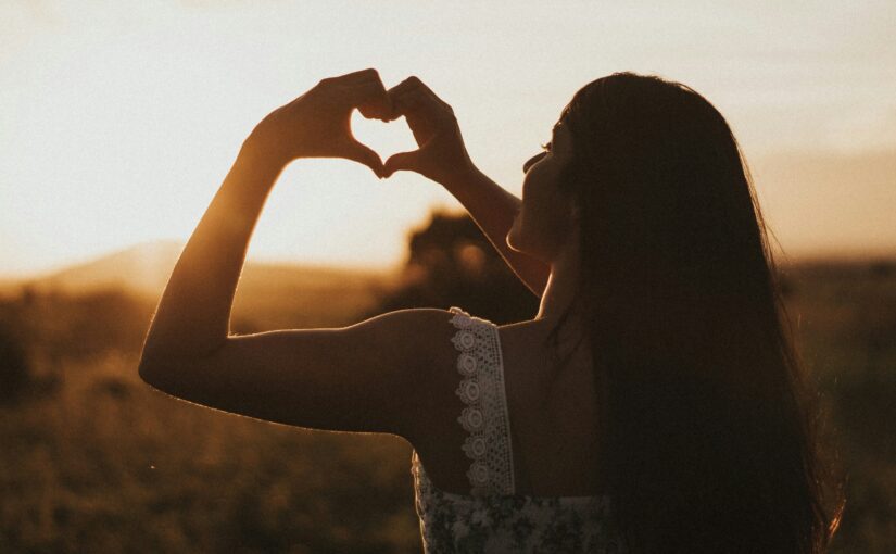 girl making a heart in blog about focusing on self without guilt by erin moore, centered one