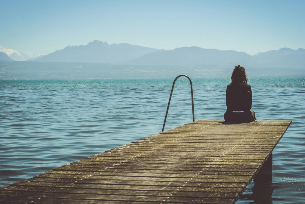 pensive girl on dock in blog by erin moore centered one about how to respond to love bombing