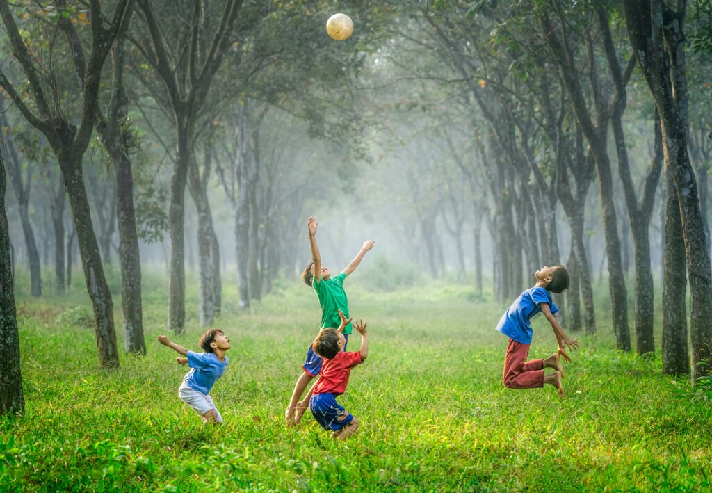 happy children playing ball in field in blog about healing from abandonment by erin moore centered one