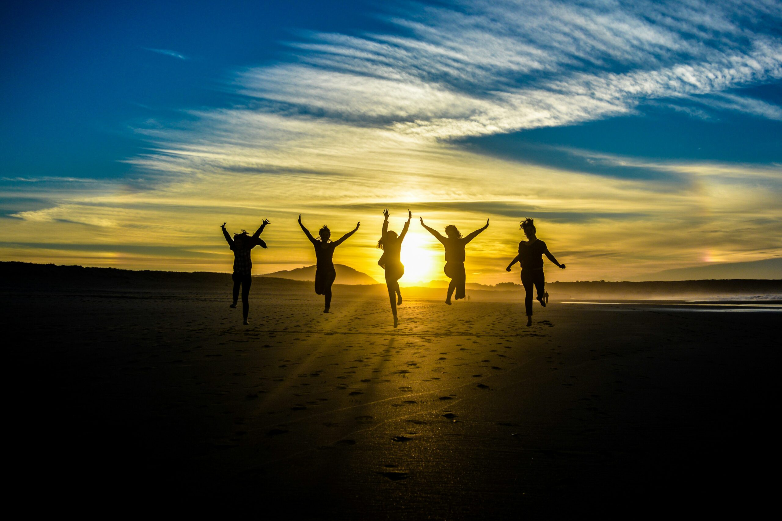 group of happy people running at sunset in blog about types of empaths by erin moore centered one
