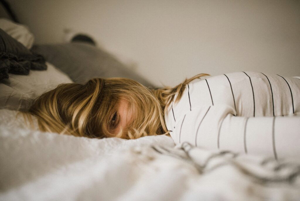 girl fell on bed in blog about somatic exercises for anxiety by erin moore centered one