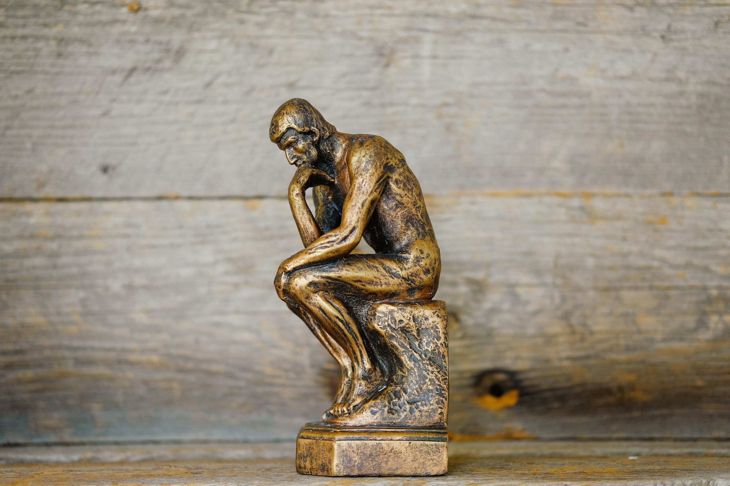 gold thinker statue in blog about stop ruminating thoughts by erin moore centered one