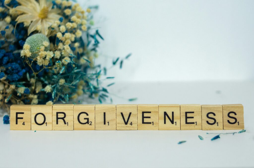 scrabble letters spelling forgiveness in blog about sibling rivalry by erin moore centered one