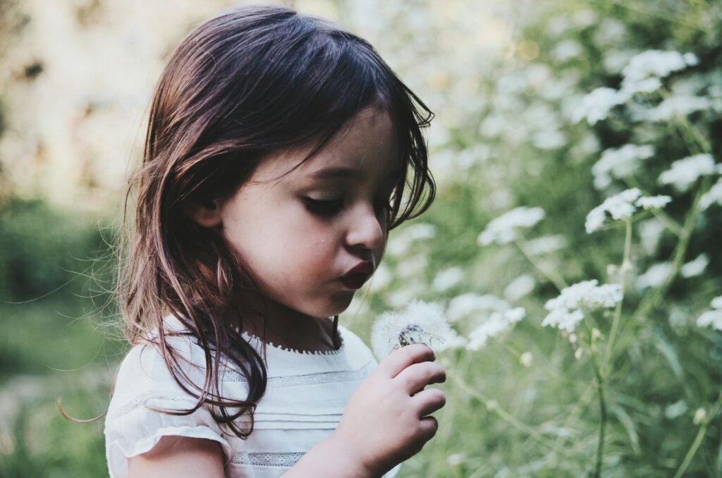 girl in garden with dandelion in blog about self worth by erin moore centered one