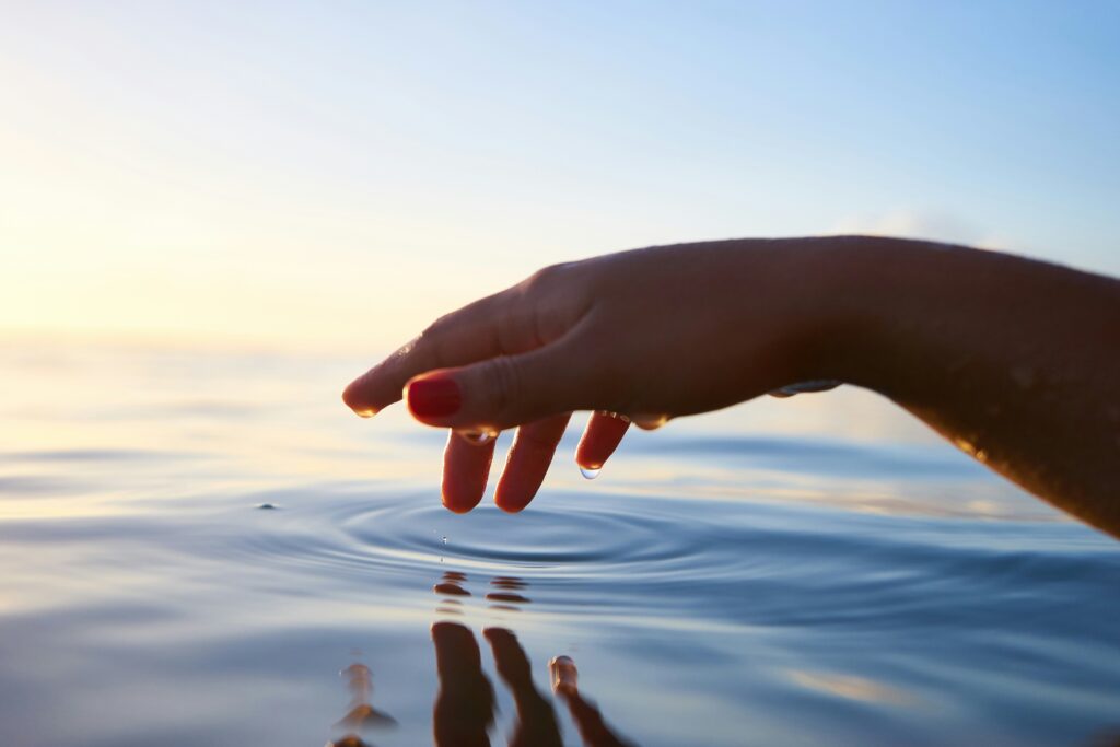 hand over water ripples in blog about complex trauma by erin moore centered one